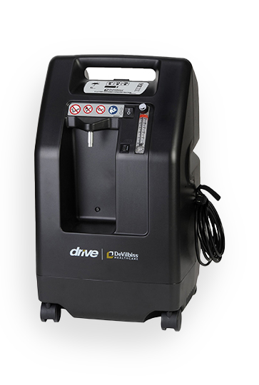 Der kompakte DeVilbiss® 5-Liter-Sauerstoffkonzentrator 525KS (Hersteller DeVilbiss), vertrieben von PMT Medizintechnik GmbH, zeigt sein schwarzes Gehäuse mit Bedienfeld, Rollen und Tragegriff.